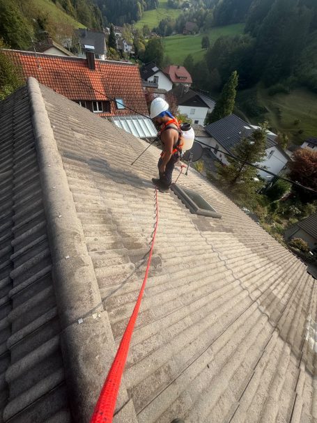 Mitarbeiter bei der professionellen Dachreinigung mit Seilsicherung